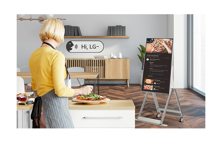 Một người phụ nữ đang sử dụng khẩu lệnh để điều khiển One:Quick Flex trong khi nấu ăn.